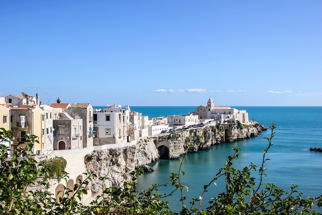 Panorama di Vieste con il mare cristallino e le scogliere bianche al tramonto.